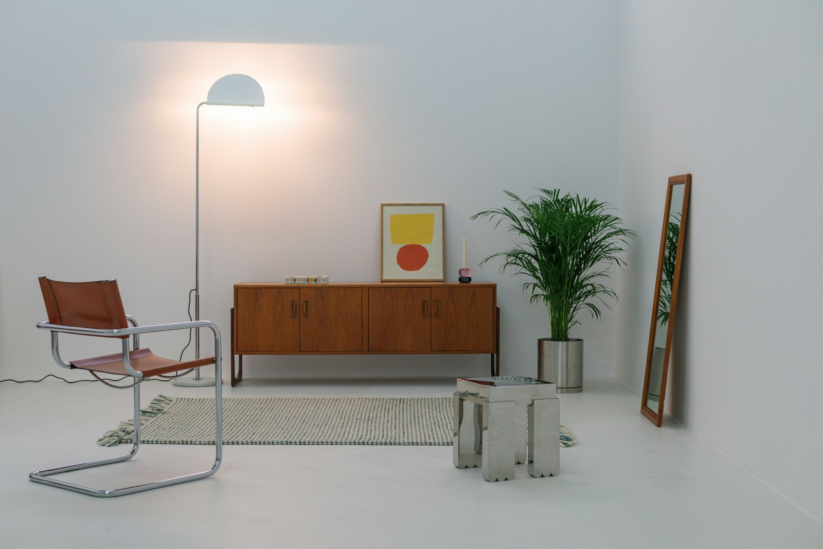 Vintage wood sideboard, tubular steel chair, and modern lighting